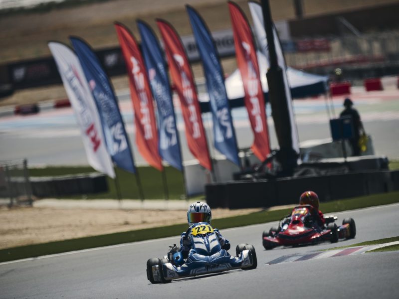 Reid Eck #221 racing past the series flags at Champions of the Future America